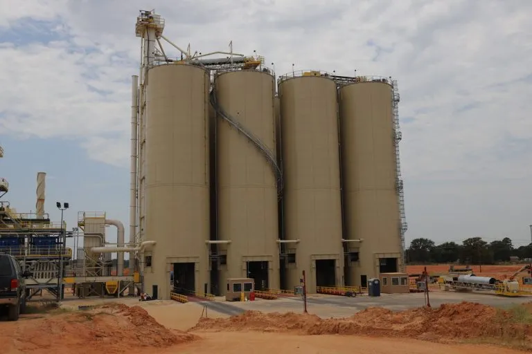 Dry bulk storage tanks with automated truck loadout