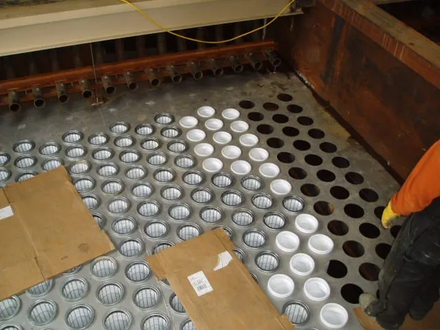 Filter bags and cages being installed in a baghouse tubesheet